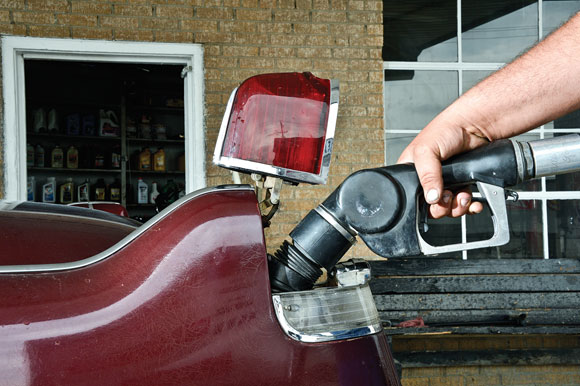 The taillight of John Faust's 1956 Cadillac Sedan de Ville pops up to accept a fill-up from the hand of Michael Pennington at Henderson Oil & Propane's full-service gas station Tuesday. The service station, one of the last of a dying breed, was planning to shut down the full-service part of the operation at the close of business Wednesday, converting to self-serve. They're also getting out of the tire and battery business to put more emphasis on propane, oil and lubricants.